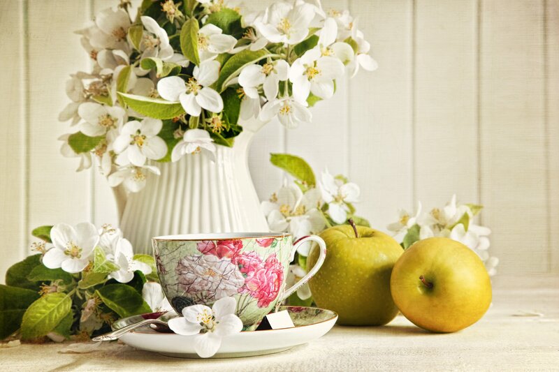 Teacup with apples and flowers