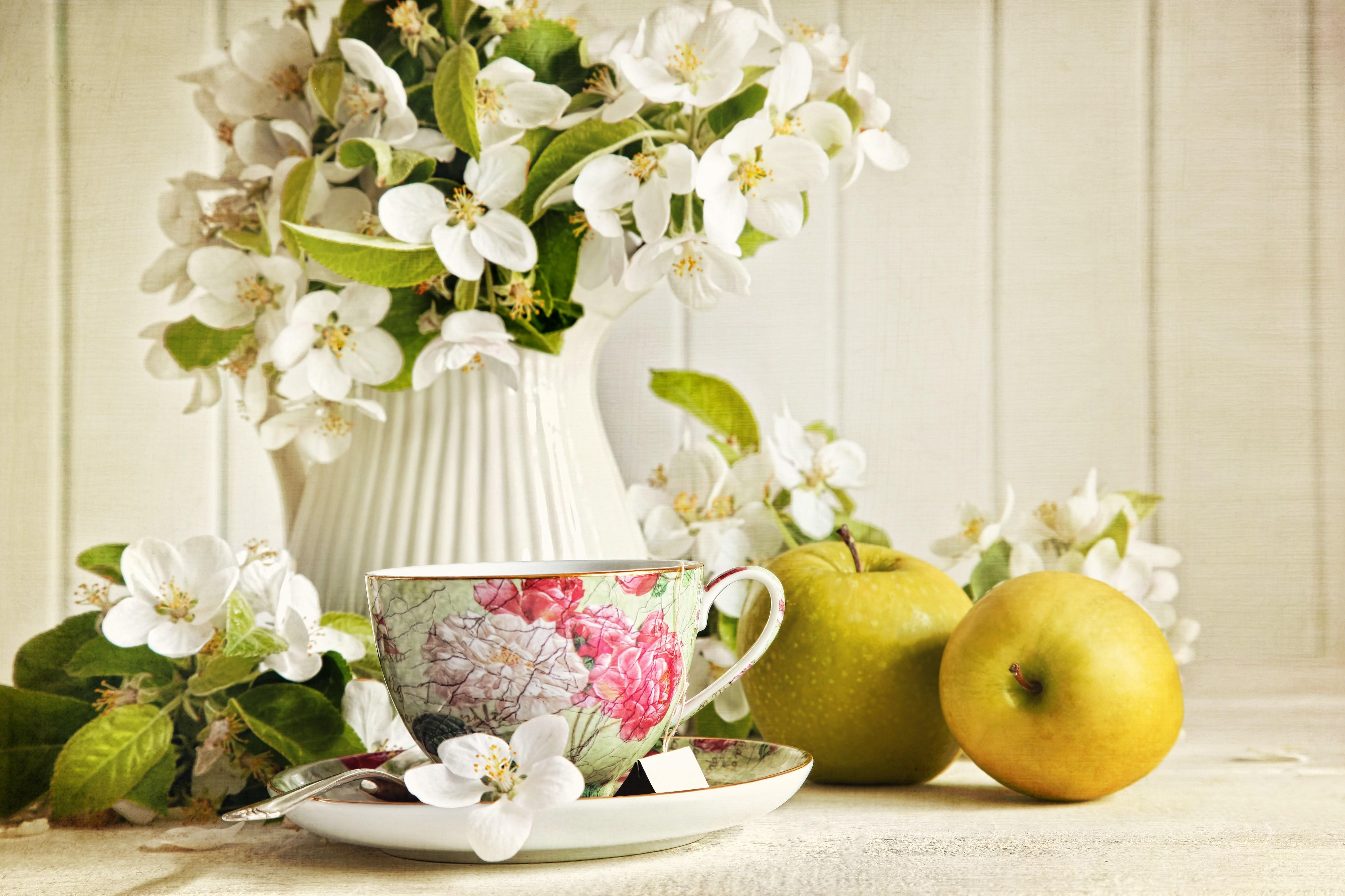 Teacup with apples and flowers