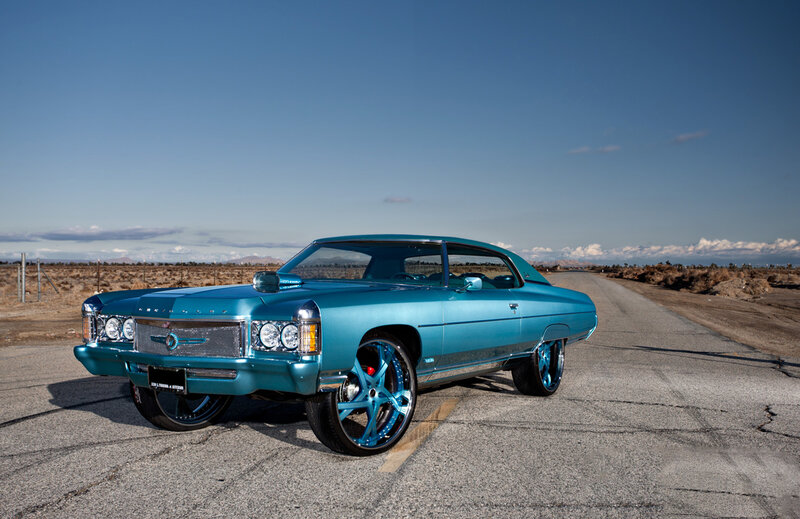 teal classic car on desert road