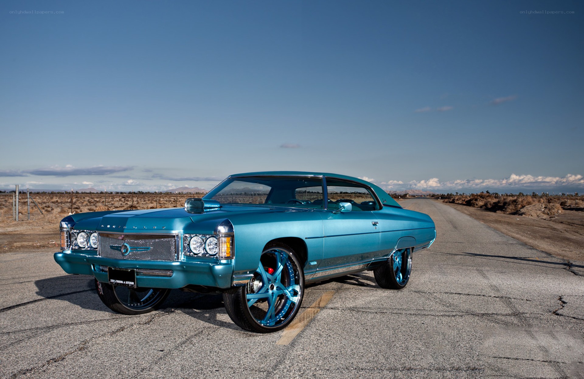 teal classic car on desert road
