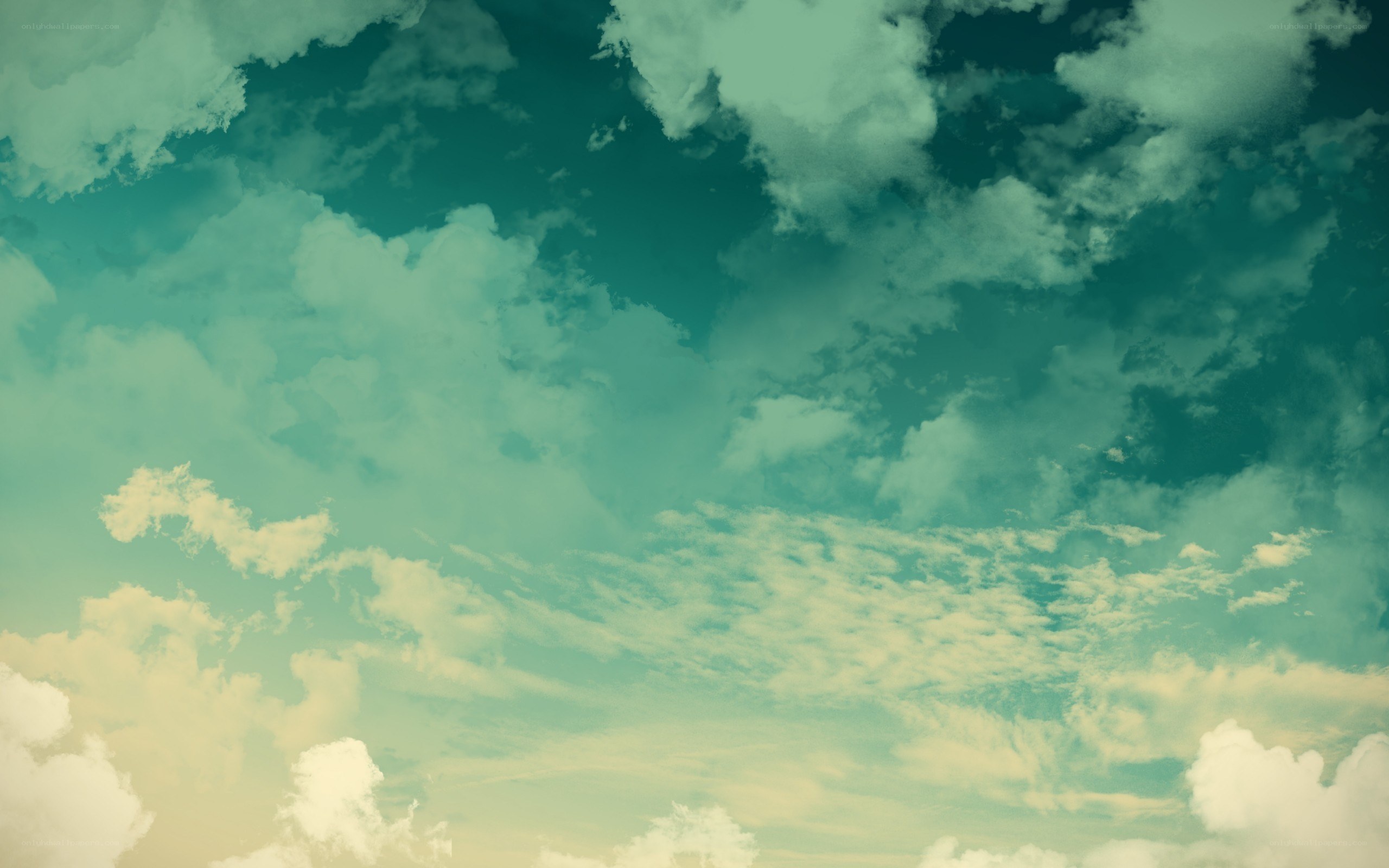 teal sky with fluffy clouds