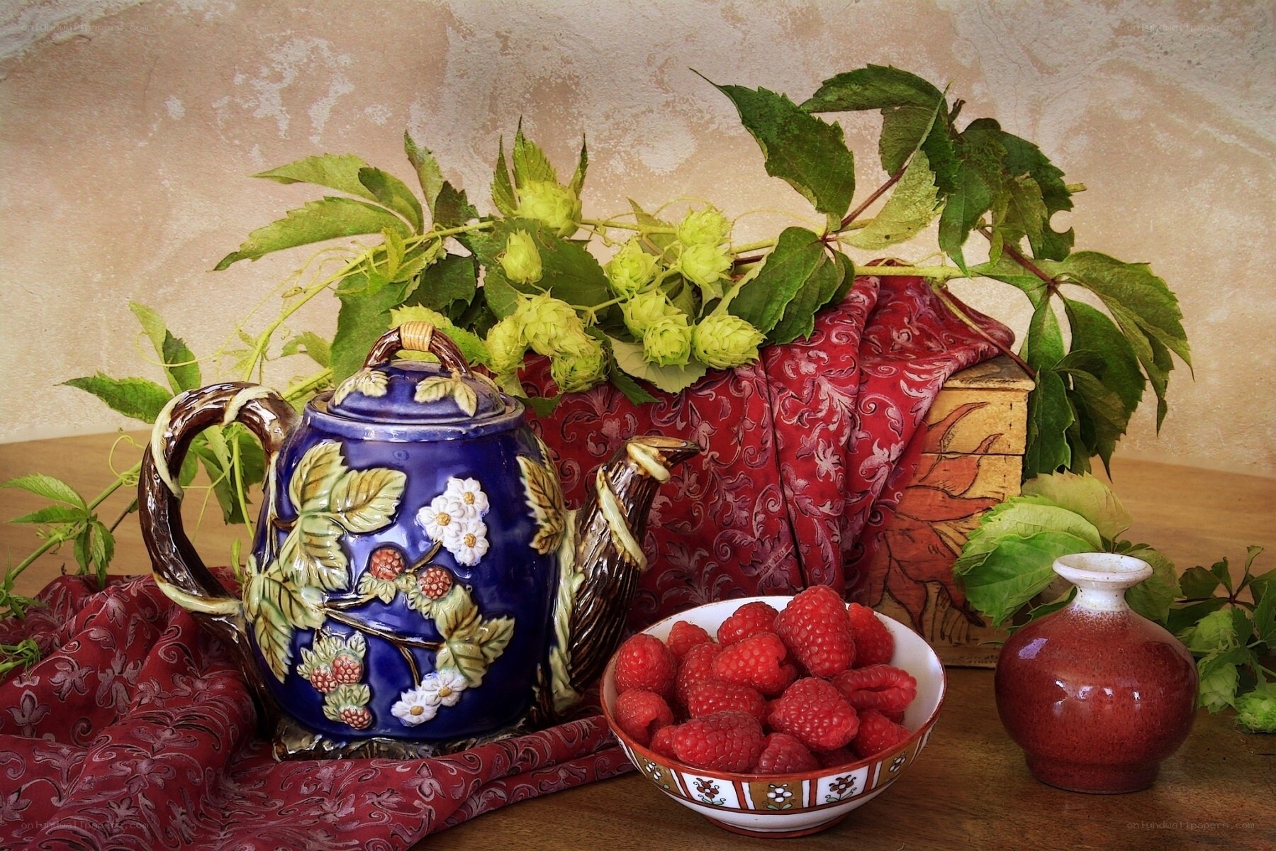 Teapot with raspberries and hops