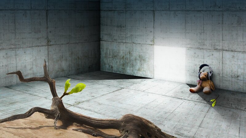 Teddy bear with headphones in concrete room