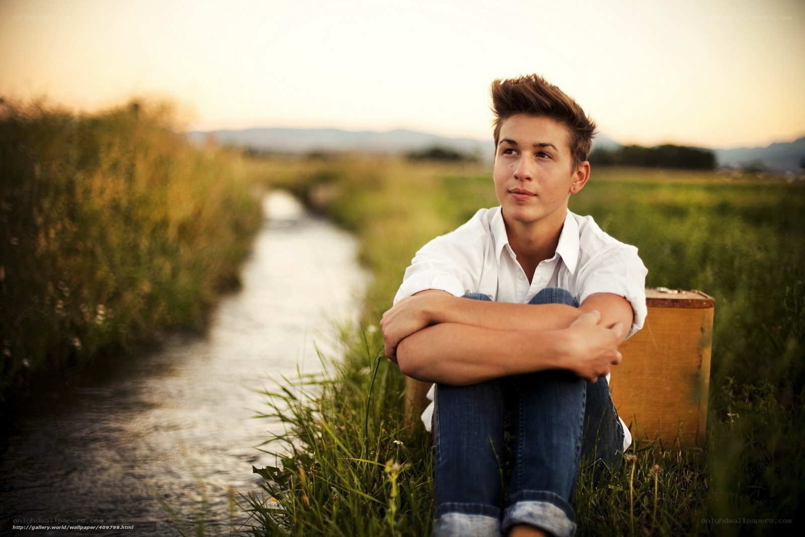 Teen by a stream at sunset