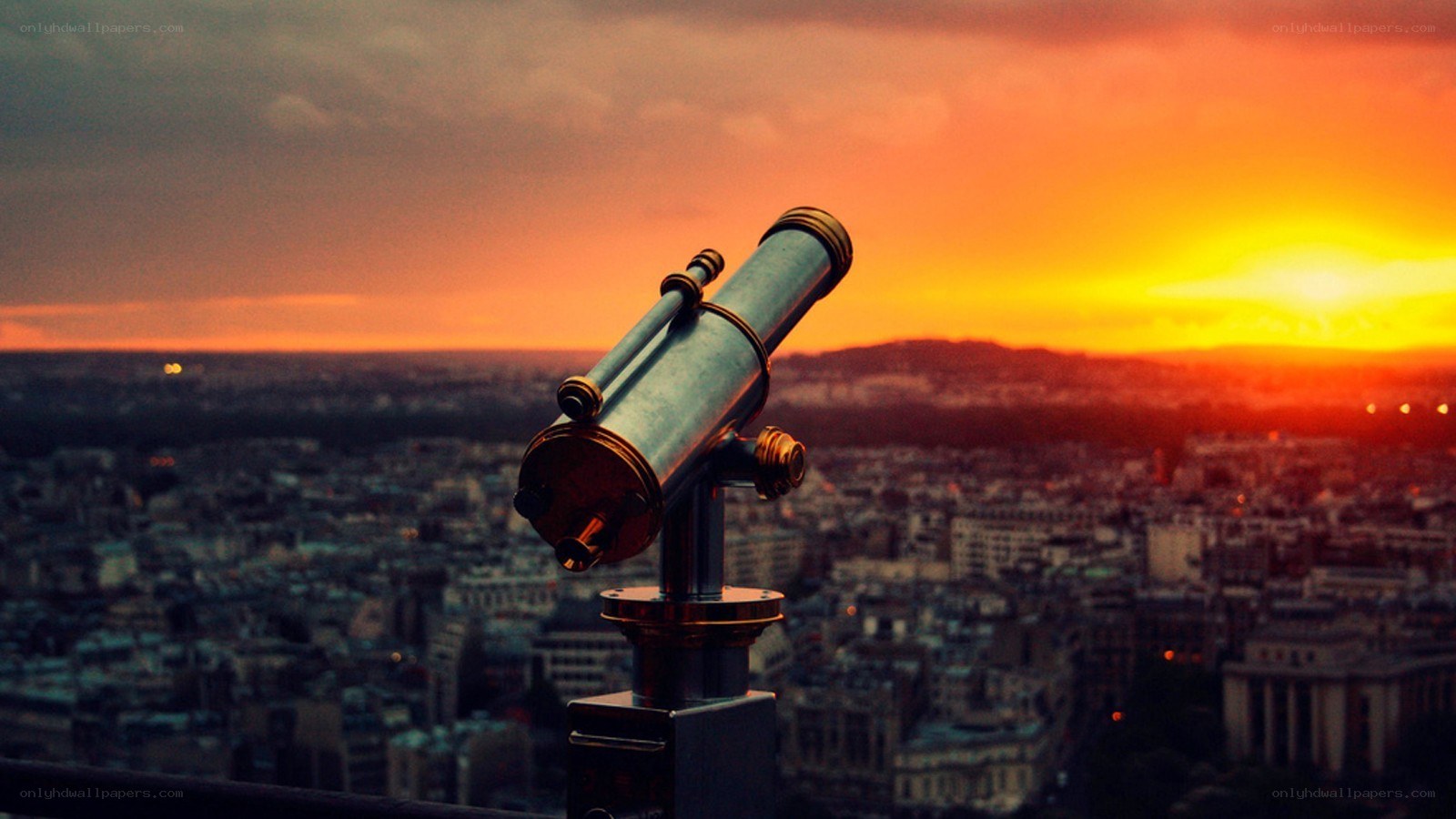 Telescope overlooking city at sunset