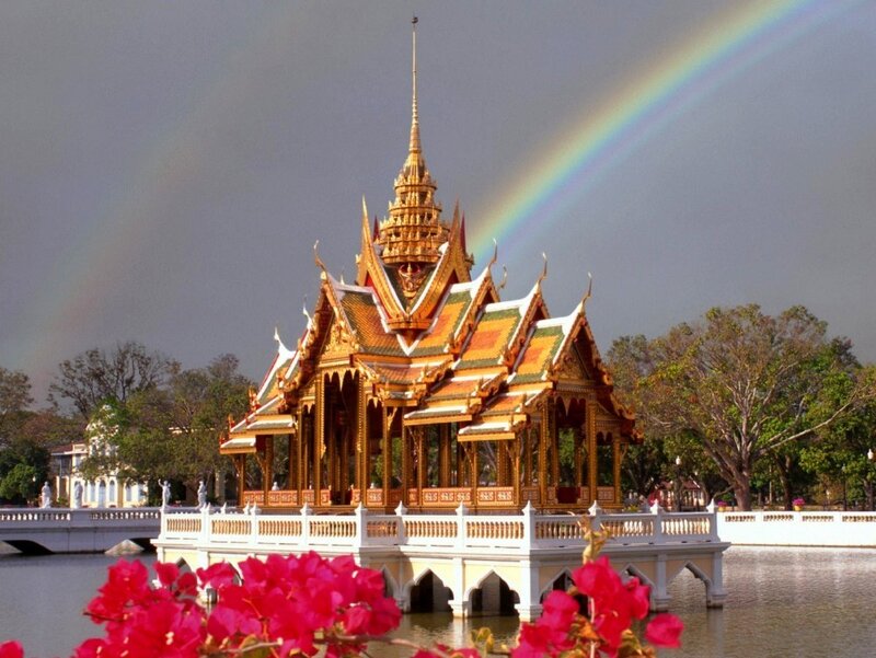 Temple with rainbow over water