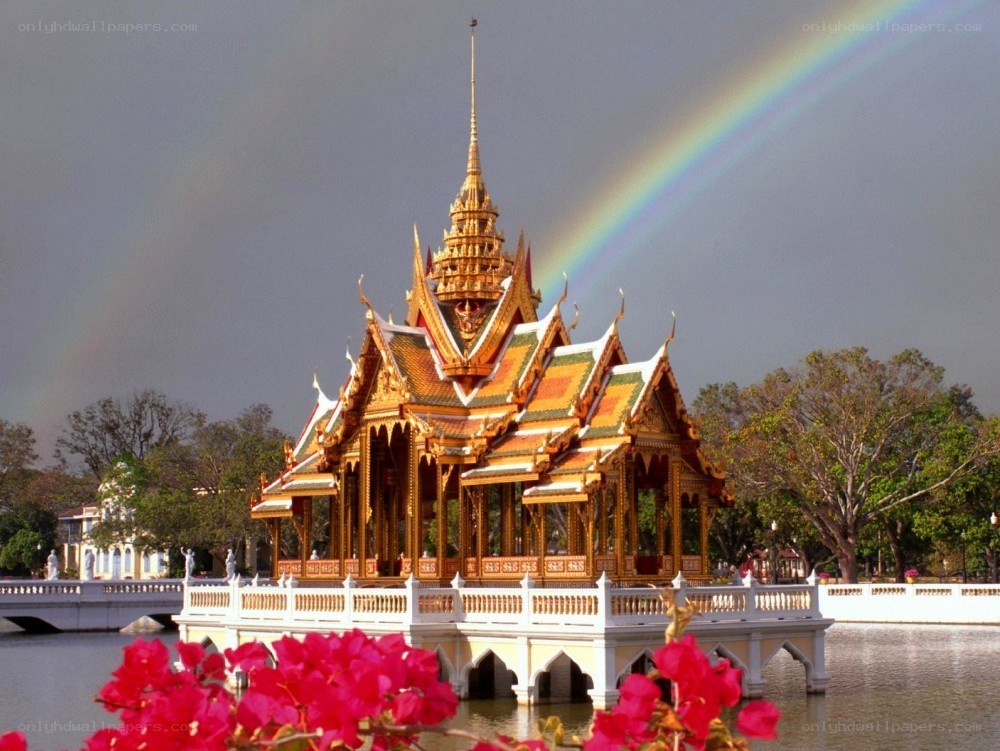 Temple with rainbow over water