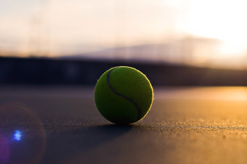 Tennis ball on court at sunset