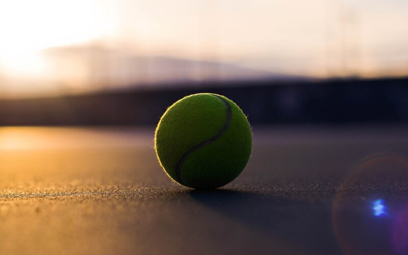 tennis ball on court at sunset
