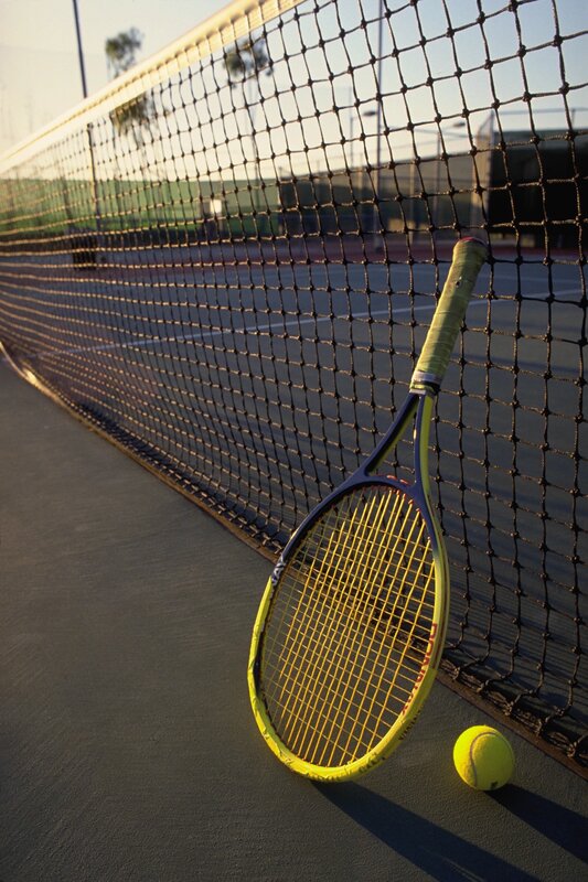 Tennis racket and ball on court