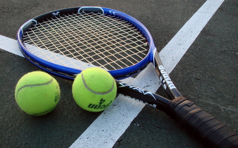 tennis racket and balls on court