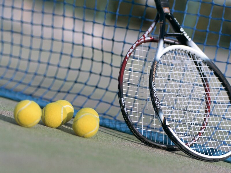 Tennis racket and balls on court