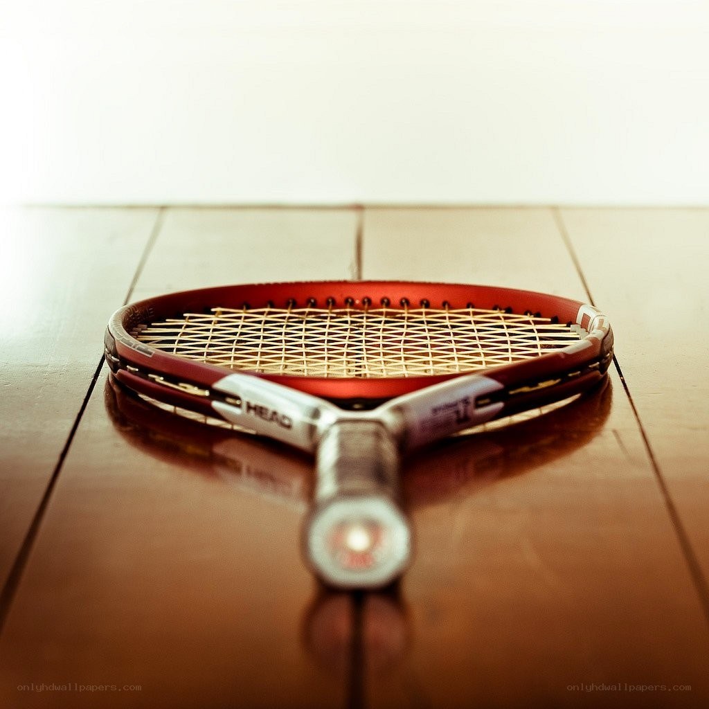 tennis racket on wooden floor
