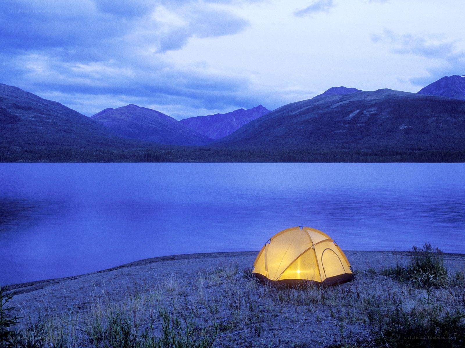 Tent by a lake at dusk