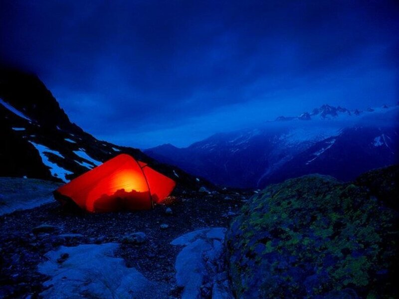 Tent lit at night in mountains
