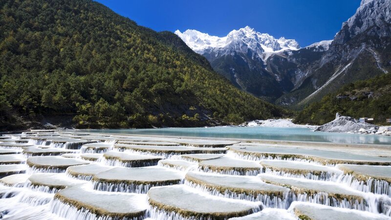 Terraced waterfalls and snow-capped mountains
