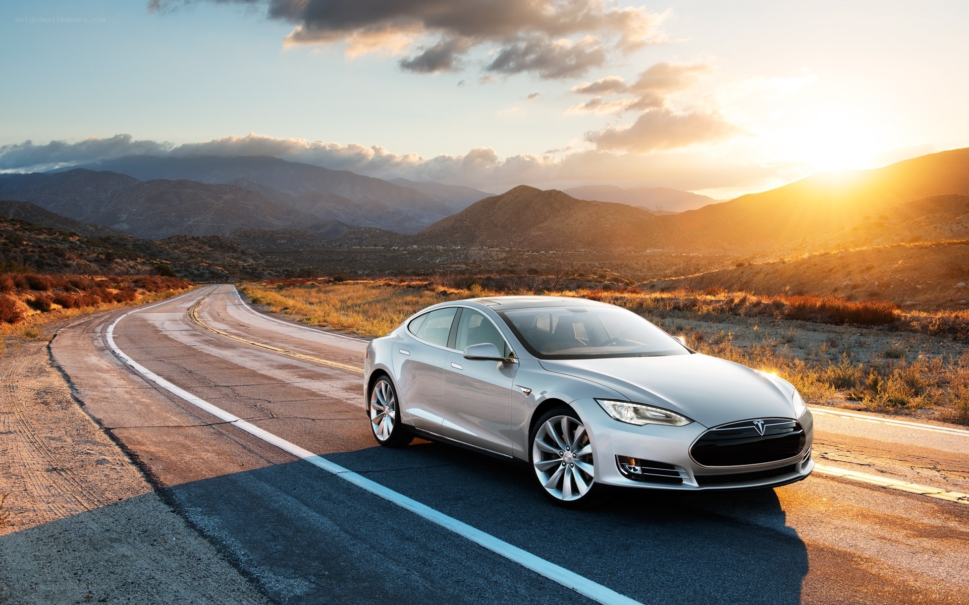 Tesla on a winding road at sunset