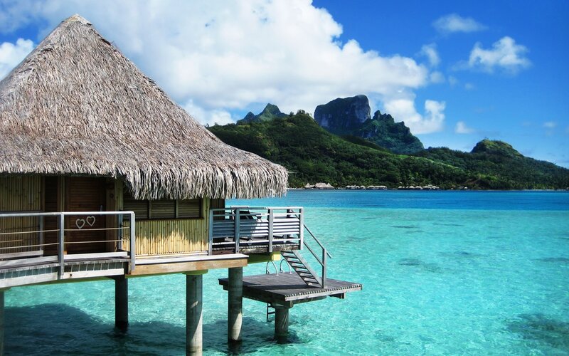 Thatched Bungalow over Water — Blue, Serene, Afternoon, Photograph, Ocean