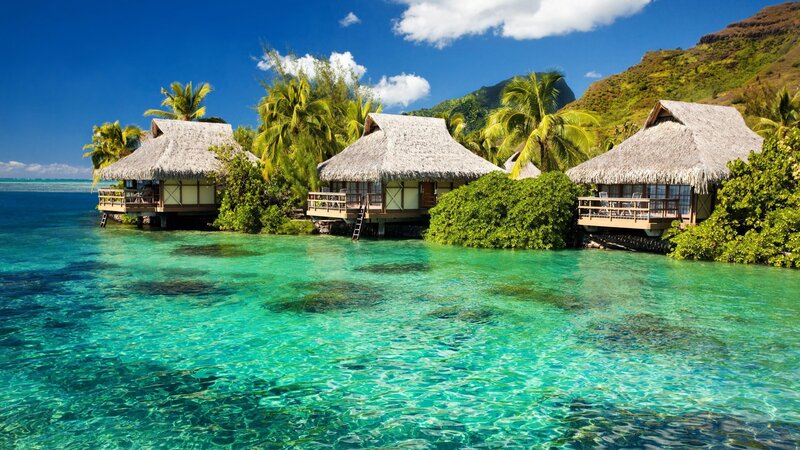 Thatched Bungalows on Water — Blue, Serene, Afternoon, Photograph, Palm Trees, Mountain, Ocean, Green