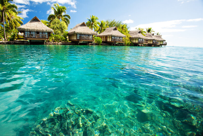 Thatched Bungalows on Water — Blue, Serene, Afternoon, Photograph, Palm Trees, Ocean, Sky