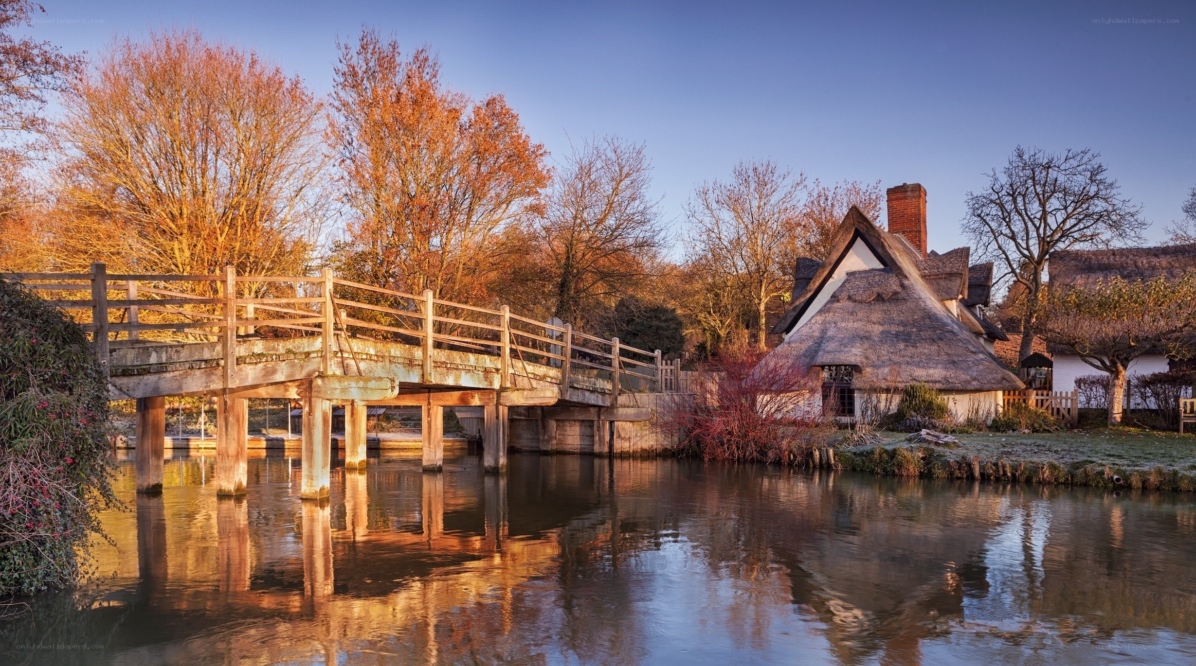 Thatched cottage by river at dawn