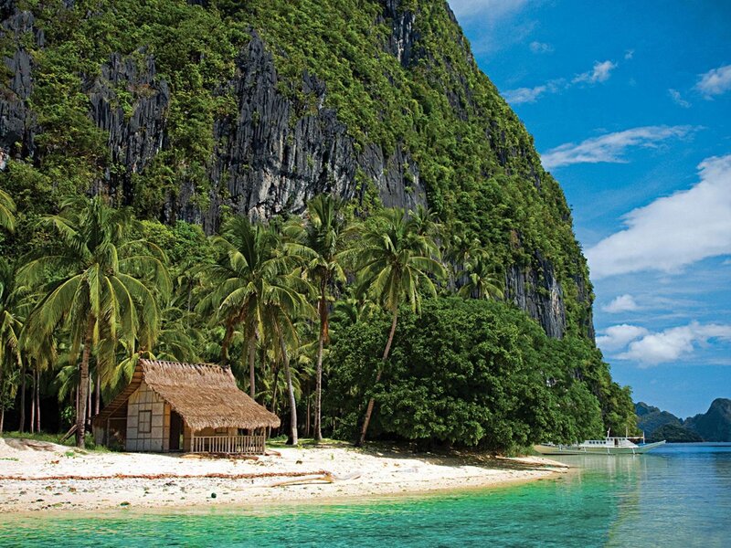 Thatched Hut on Beach — Blue, Serene, Afternoon, Photograph, Palm Trees, Cliff, Boat