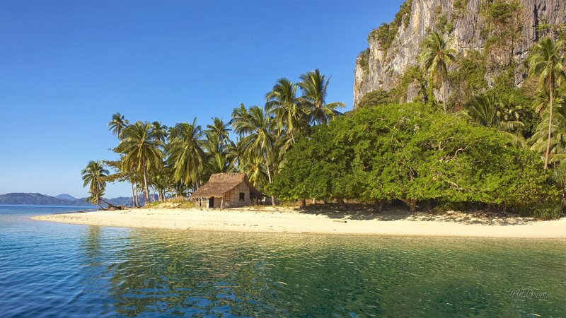 Thatched Hut on Beach — Blue, Serene, Afternoon, Photograph, Palm Trees, Cliff, Sand