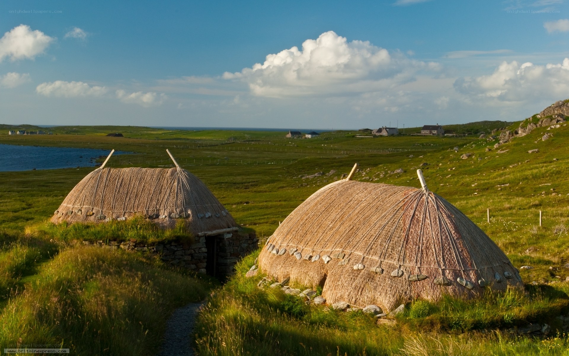 thatched huts on a grassy hill