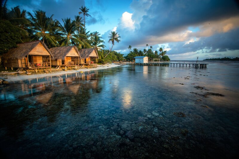 Thatched Huts on Beach — Blue, Serene, Sunset, Photograph, Palm Trees, Coral Reef