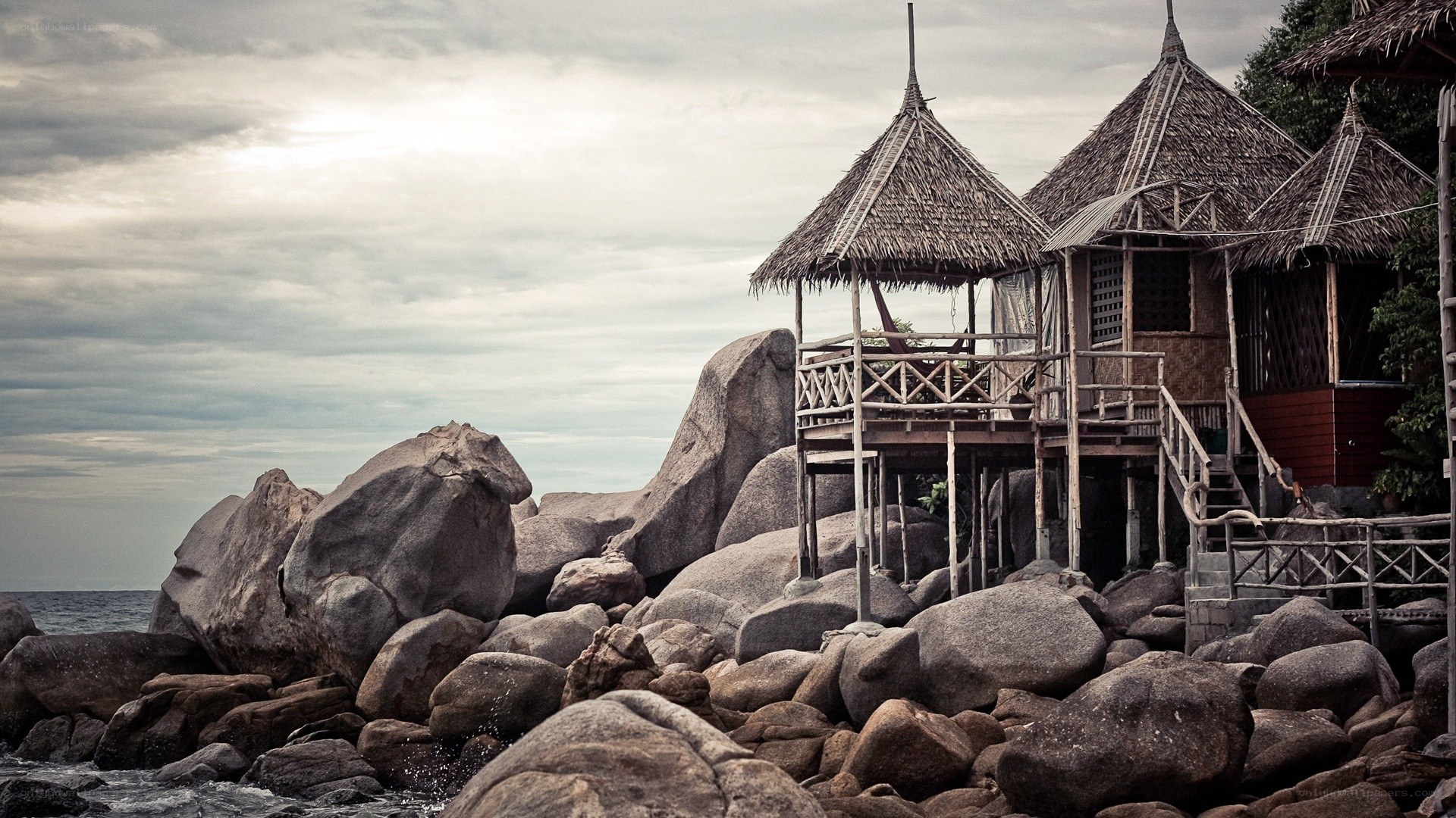 Thatched huts on rocky shore