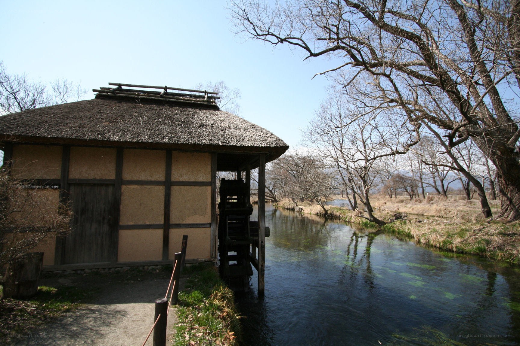 Thatched mill by a river