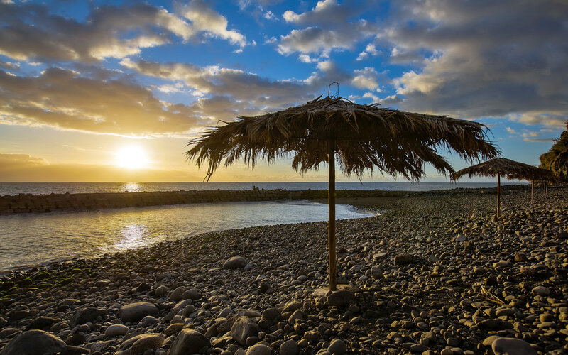 Thatched Umbrellas on Beach — Blue, Serene, Sunset, Photograph