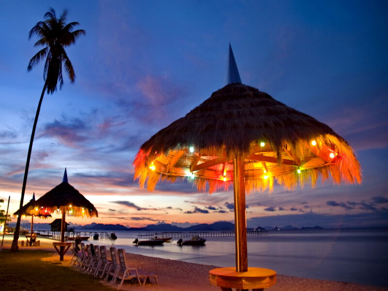 Thatched Umbrellas on Beach — Blue, Serene, Sunset