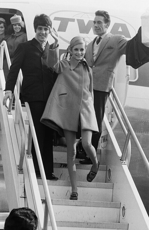 The Beatles and a woman disembarking from an airplane