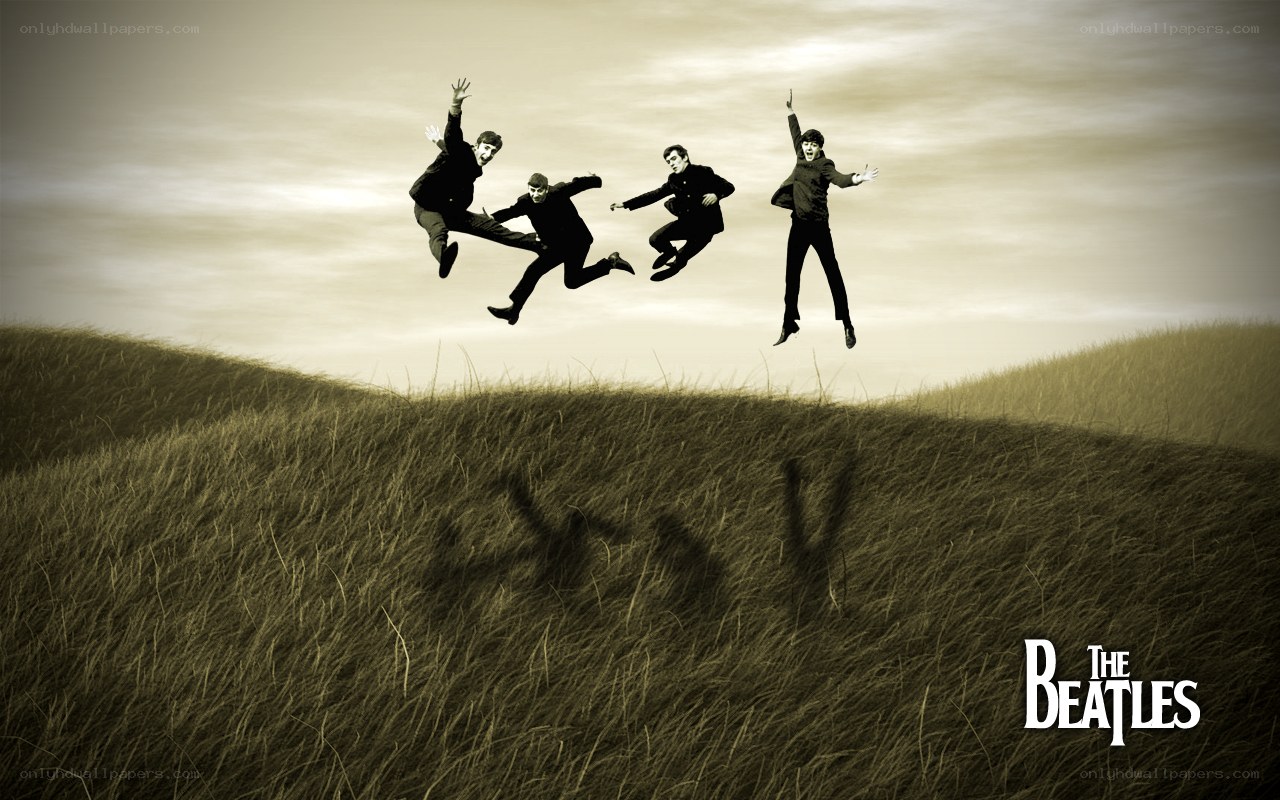 The Beatles jumping in a field
