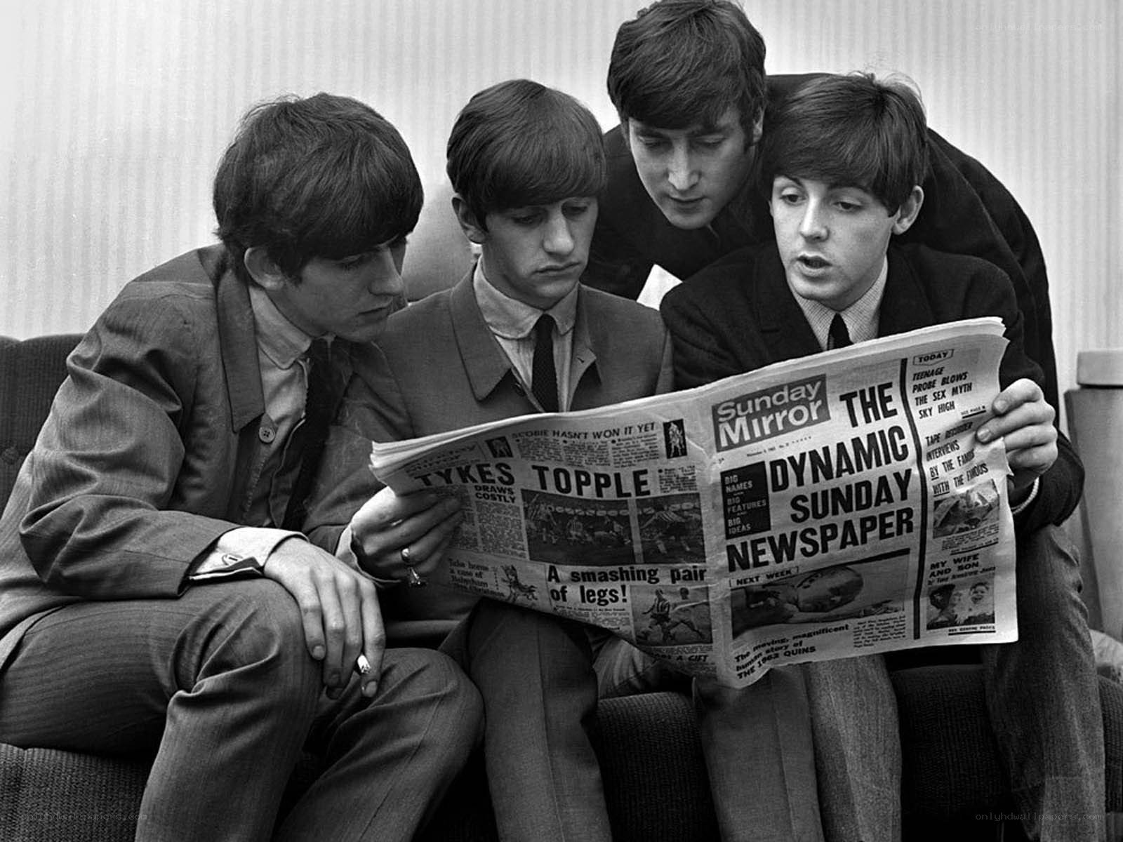 The Beatles reading a newspaper