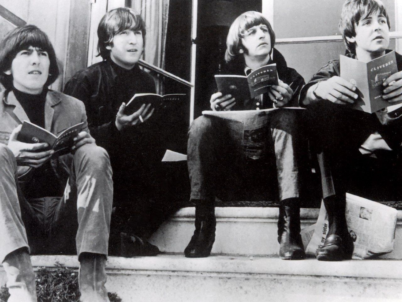 The Beatles reading books on steps
