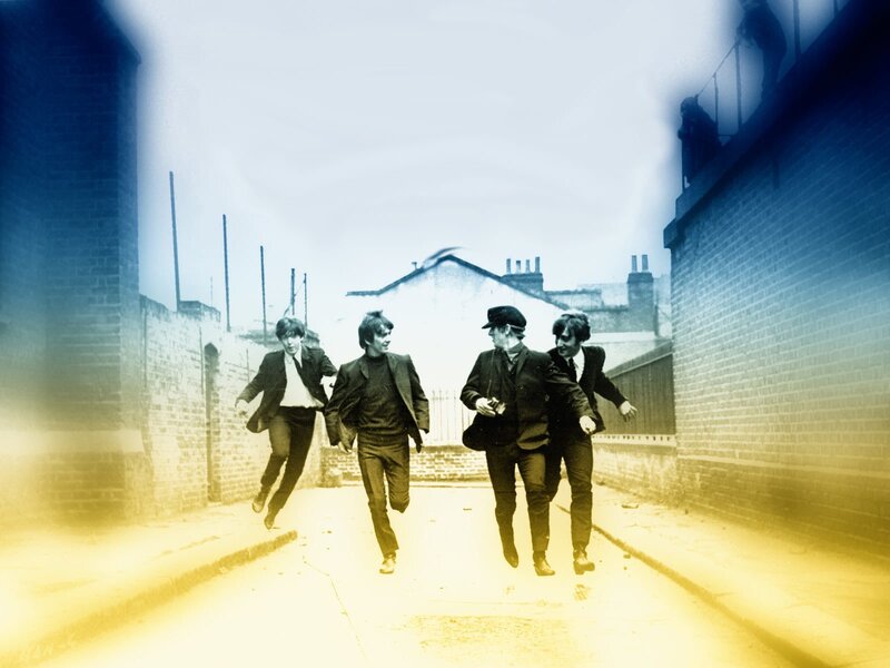 The Beatles running in an alley