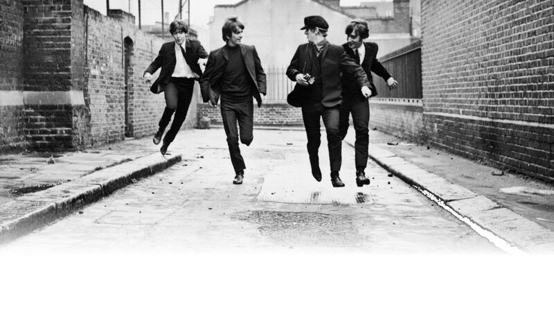 The Beatles running in an alley