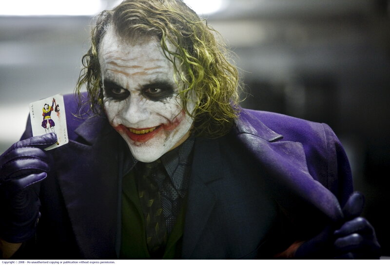 The Joker holding a card