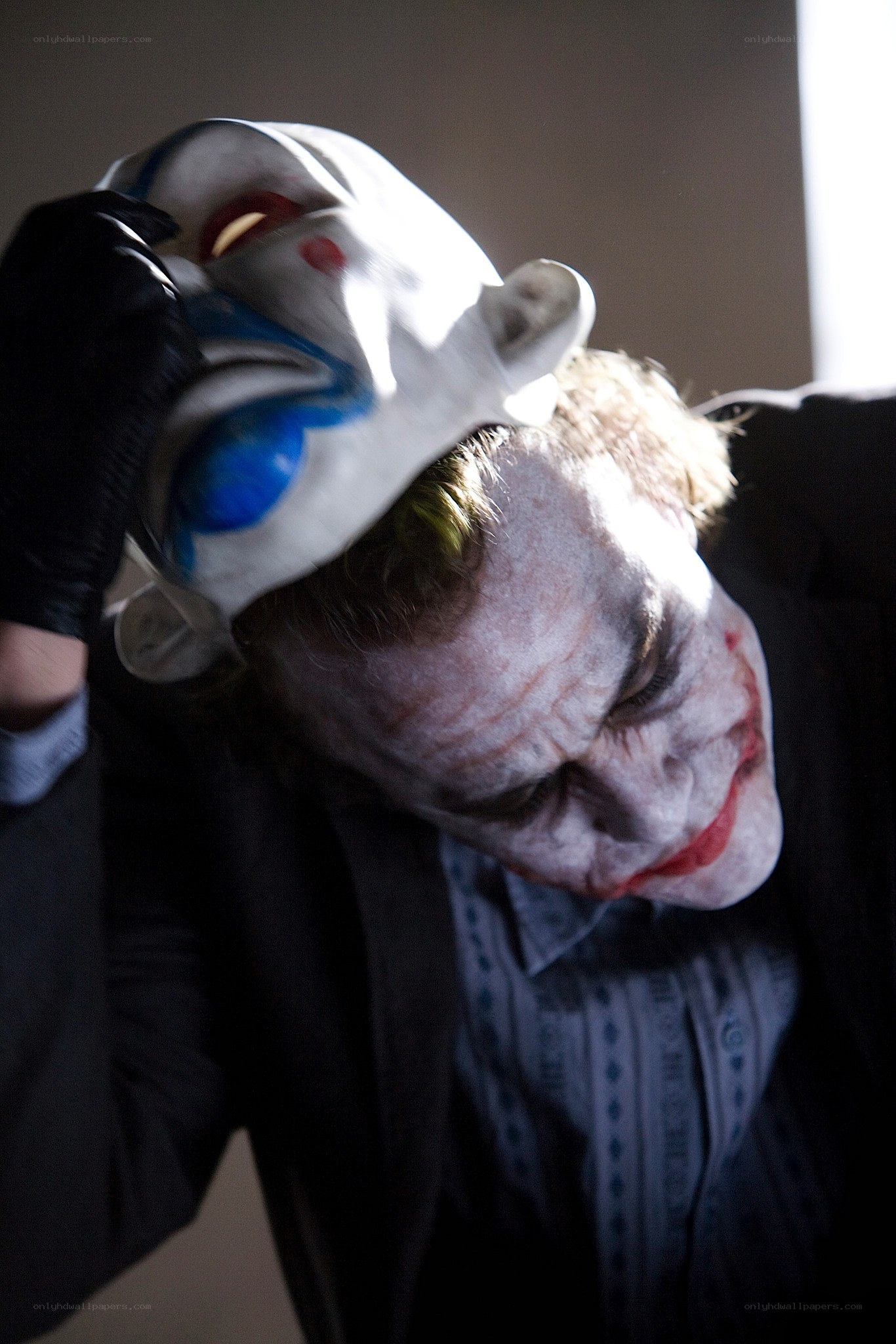The Joker removing his mask
