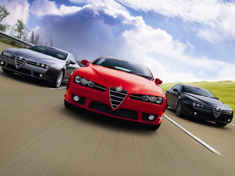 Three Alfa Romeo cars on a road