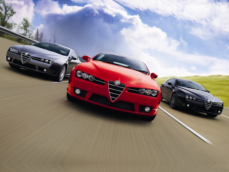Three Alfa Romeo cars on a road