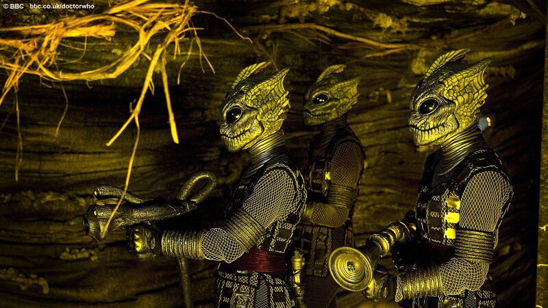 three alien figures in a cave