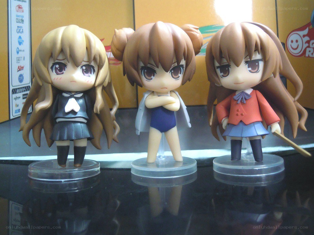 Three anime figurines on display