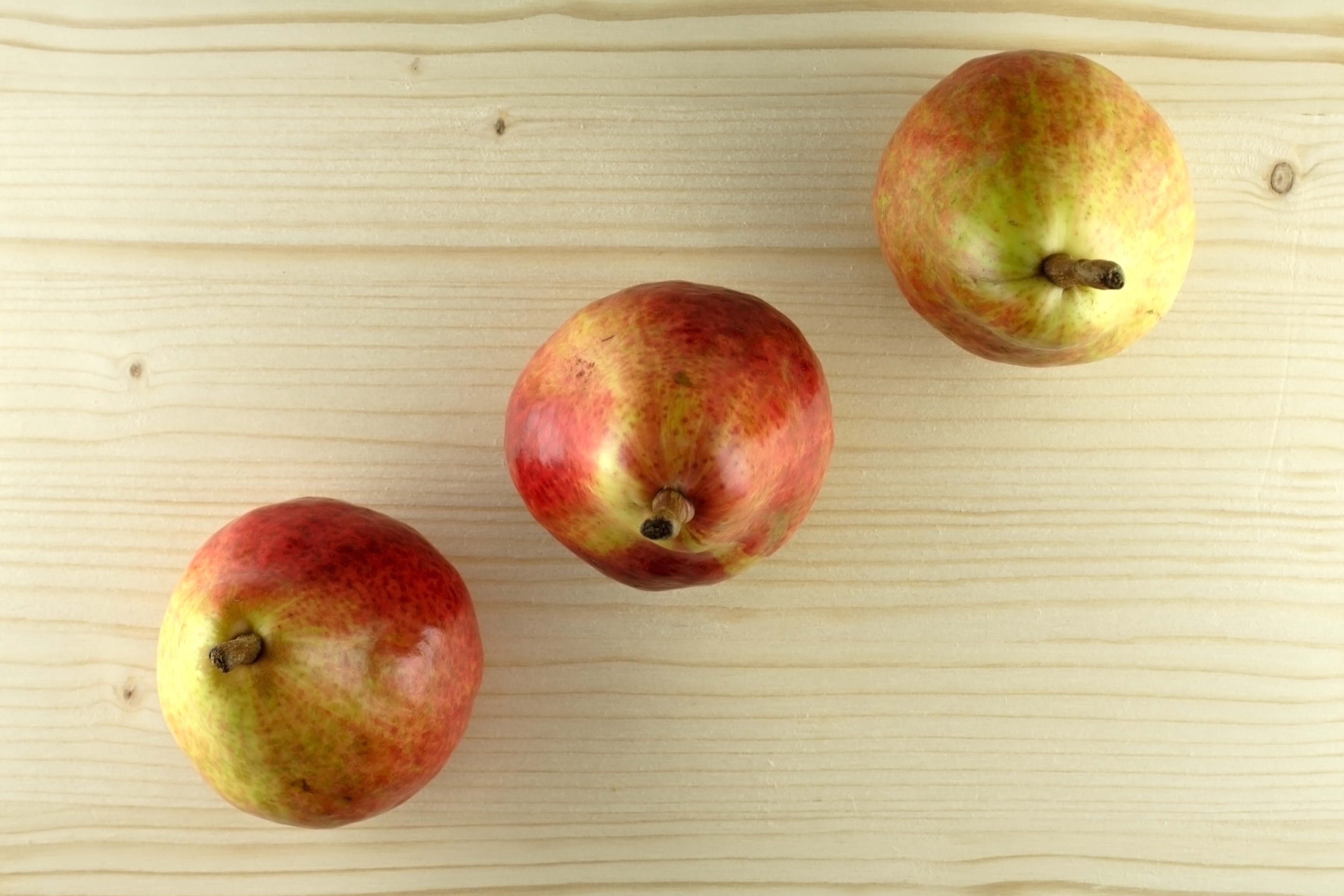 three apples on wood