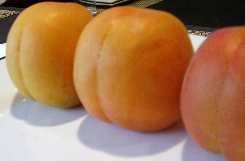 three apricots on a plate