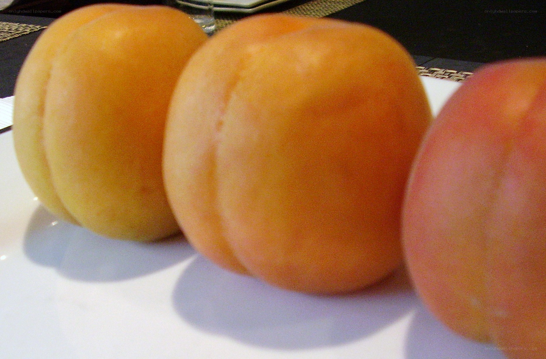 three apricots on a plate