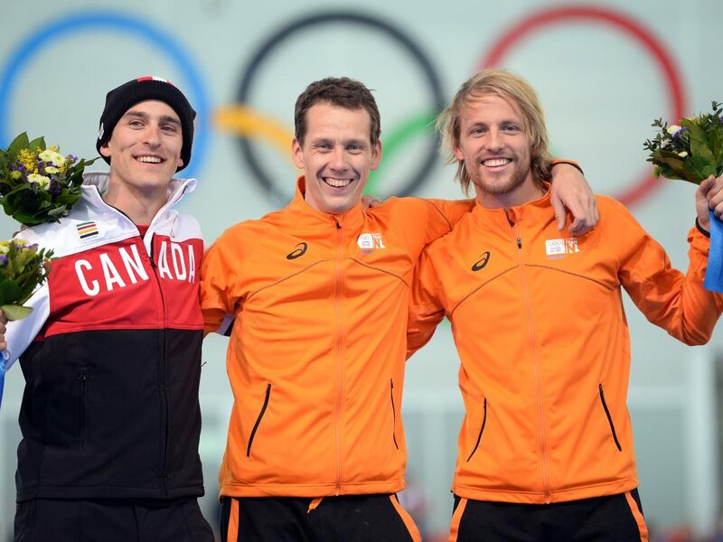 Three Athletes on Podium — Orange, Celebratory