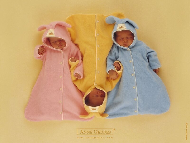 Three babies in colorful sleepers